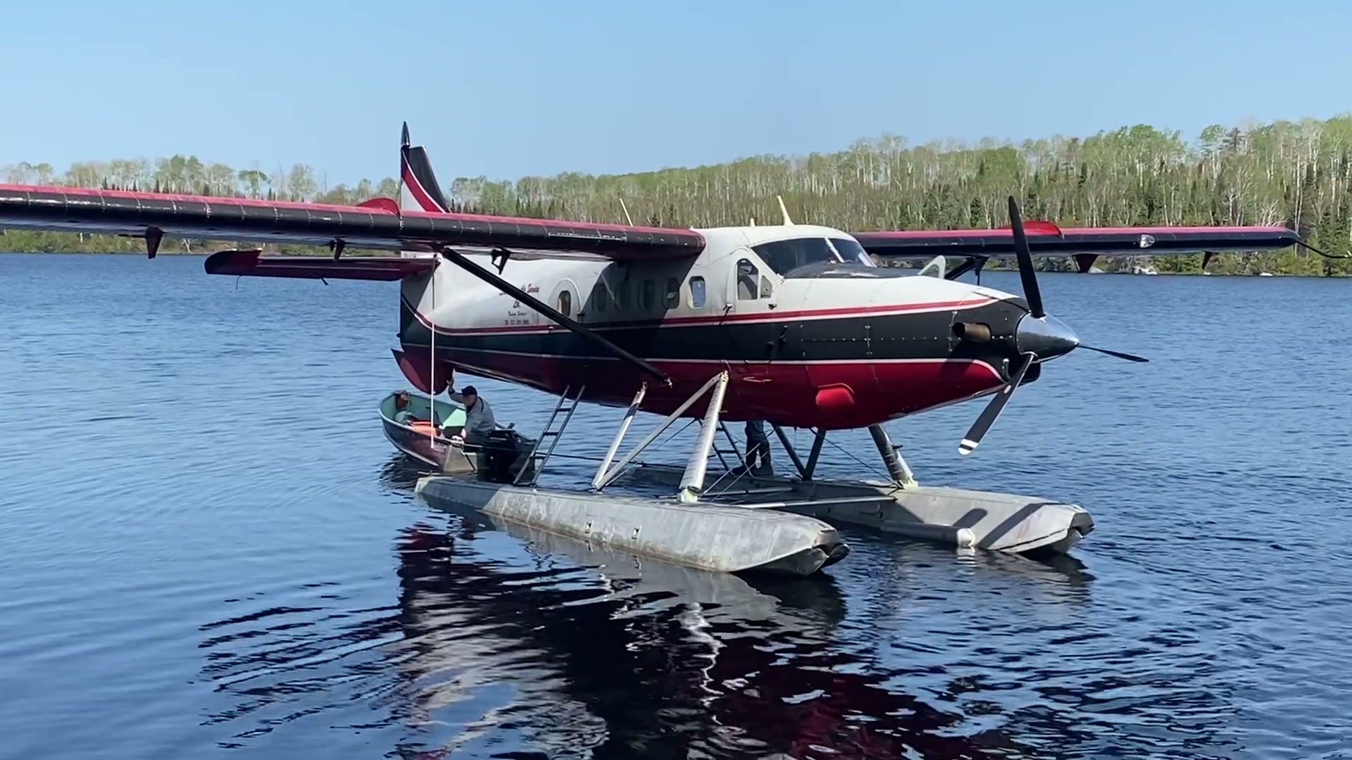 Towing the floatplane into open water with the camp boat at Van Poele