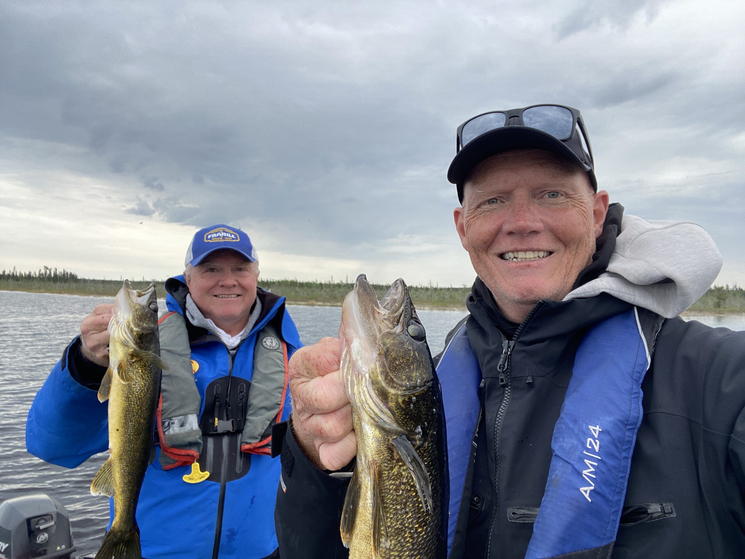 Scott and Chris each holding a walleye on Van Poele Lake